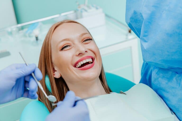 young woman smiling in a dental chair, perfect white smile